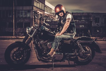 Biker and his bobber style motorcycle on a city streets