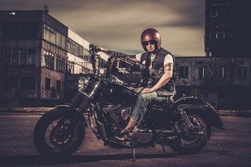 Biker and his bobber style motorcycle on a city streets © Nejron Photo