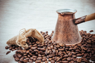 Coffee turk and roasted beans on burlap background.