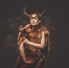 Woman shaman in ritual garment with hawk