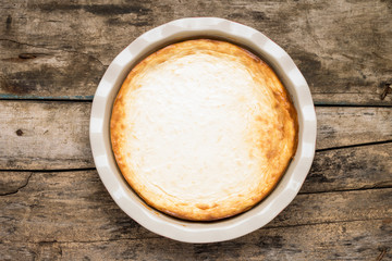 Fresh baked cheesecake on wooden table.