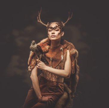 Woman shaman in ritual garment with hawk