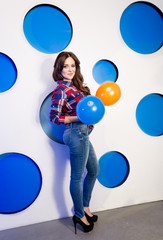 Fototapeta premium girl holding colorful balloons at studio with colorful circles