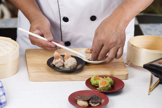 Chef using chopsticks hold Chinese dumpling