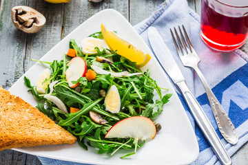 fresh salad with arugula, quail eggs, capers and apple