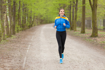 Young beautiful woman running on a trail