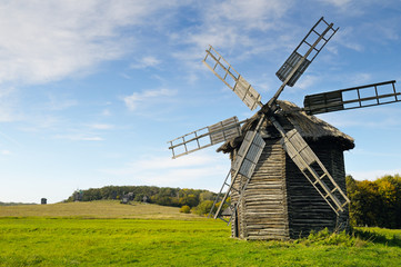 Fototapeta na wymiar old wooden windmill in a field