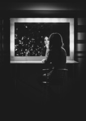 Black and white photo of woman posing in dressing room at mirror