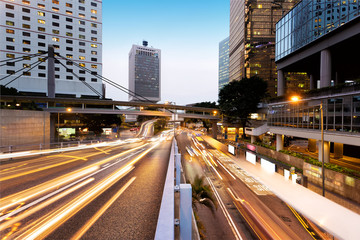 traffic light trails and office buildings in modern city