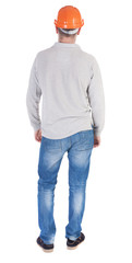 Backview of an engineer in construction helmet stands.