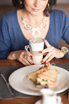 Portrait of middle-aged woman eating breakfast in cafe