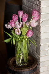 Bouquet of beautiful pastel colored pink tulips in glass vases o