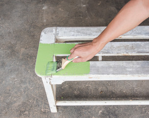 carpenter painting white bench by green color