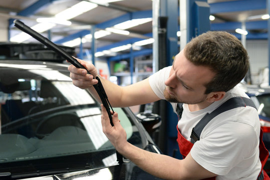 KFZ Mechaniker kontrolliert die Wischerbl&auml;tter am Auto