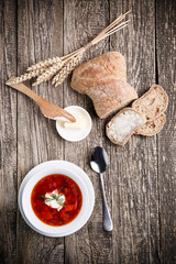 Tasty soup with bread on a wooden background.