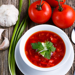 Borsch with bread on a wooden background.