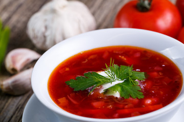 Borsch with bread on a wooden background.