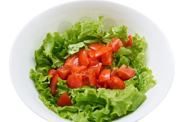 Healthy green salad, tomatoes in white bowl. Isolated on white.