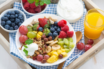 healthy breakfast - berries, fresh fruit and cereal, top view