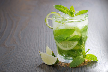 mojito cocktail and ingredients on a wooden table