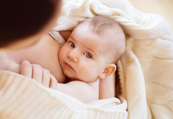 Mother breastfeeding her little baby girl in her arms