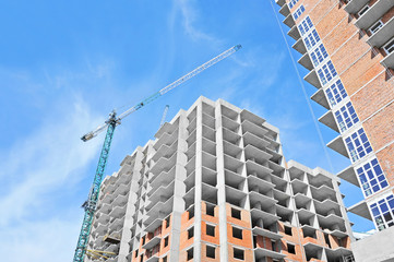Fototapeta premium Crane and building construction site against blue sky
