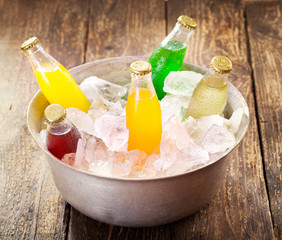 various bottles of soda in the bucket with ice - obrazy, fototapety, plakaty