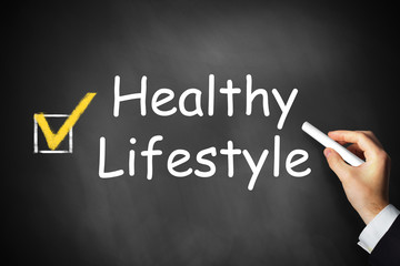 hand writing healthy lifestyle on black chalkboard