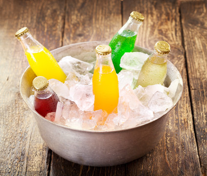 various bottles of soda in the bucket with ice