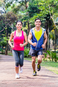Asian couple jogging or running in park for fitness