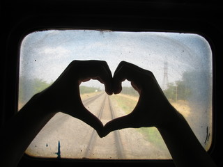 Silhouette Of Hands Making Heart On Dirty Train Window