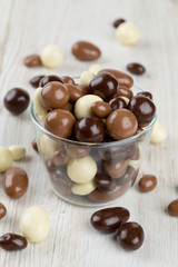 chocolate covered nuts and raisins on wooden surface