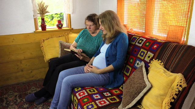 Pregnant granddaughter woman with grandma read book