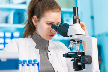 technician in the laboratory using a microscope