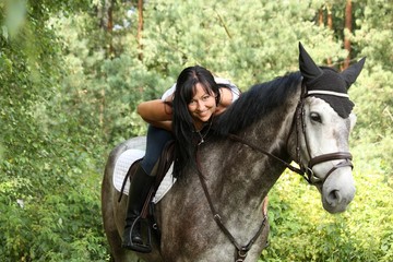 Beautiful woman and gray horse portrait in garden