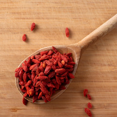 dried goji berries on the wooden spoon