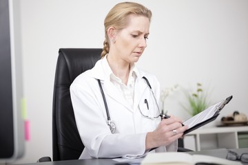 Serious Female Doctor Making Medical Findings
