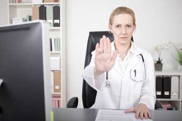 Fototapeta premium Serious Female Doctor Showing Stop Hand Pose