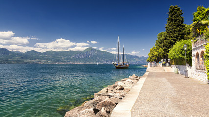 High mountains and sailing boat on the Lake Garda, Italy