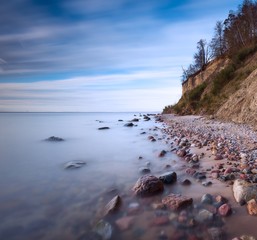 Cliff on sea shore at sunrise. Baltic sea long exposure photo