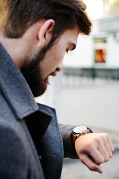a man with a beard and mustache looks at the clock