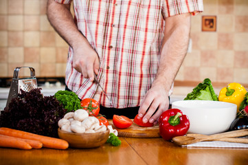 Man cuts fresh spring vegetables