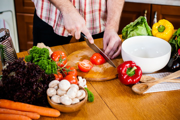 Man cuts fresh spring vegetables