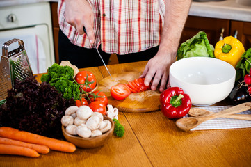 Man cuts fresh spring vegetables