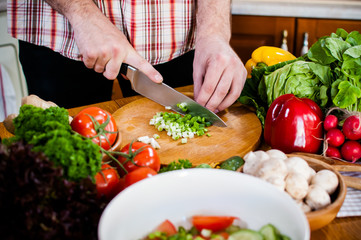 Man cuts fresh spring vegetables