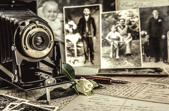 Antiker Fotoapparat steht vor alten Fotografien. Nostalgie Konzept