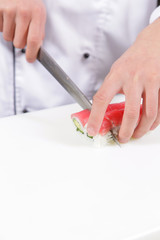 Cook cuts sushi rolls