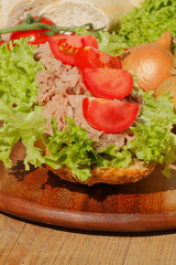 Fischbrötchen mit Thunfischfilet, Salat, Gewürzgurken, Zwiebeln