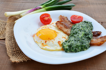 Fried egg with creamed spinach and bacon