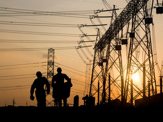 Silhouette of engineer looking at blueprints in a building site
